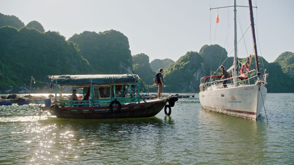 Checker Tobi steht auf einem Boot und findet gerade seine Freundin Miriam in Vietnam.