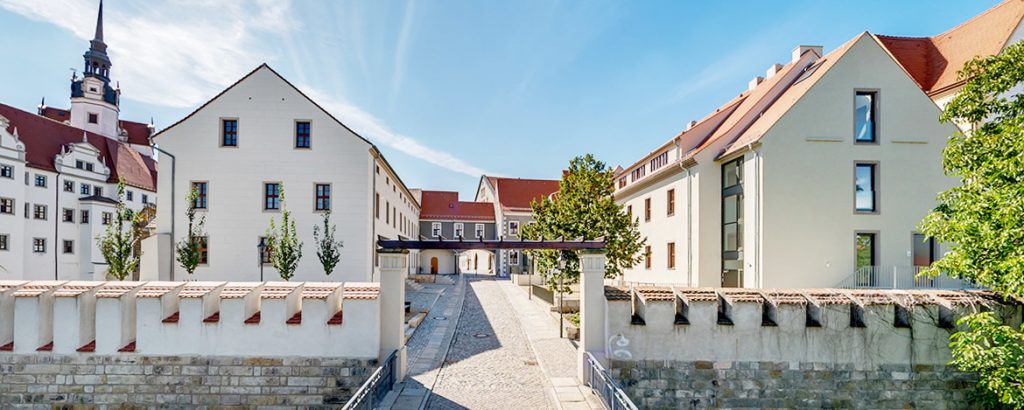 Man sieht einen Lichthof und darum frisch modernisierte Häuser.