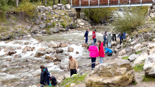 Eine Schulklasse erkundet einen Wildbach in der Nähe von Garmisch